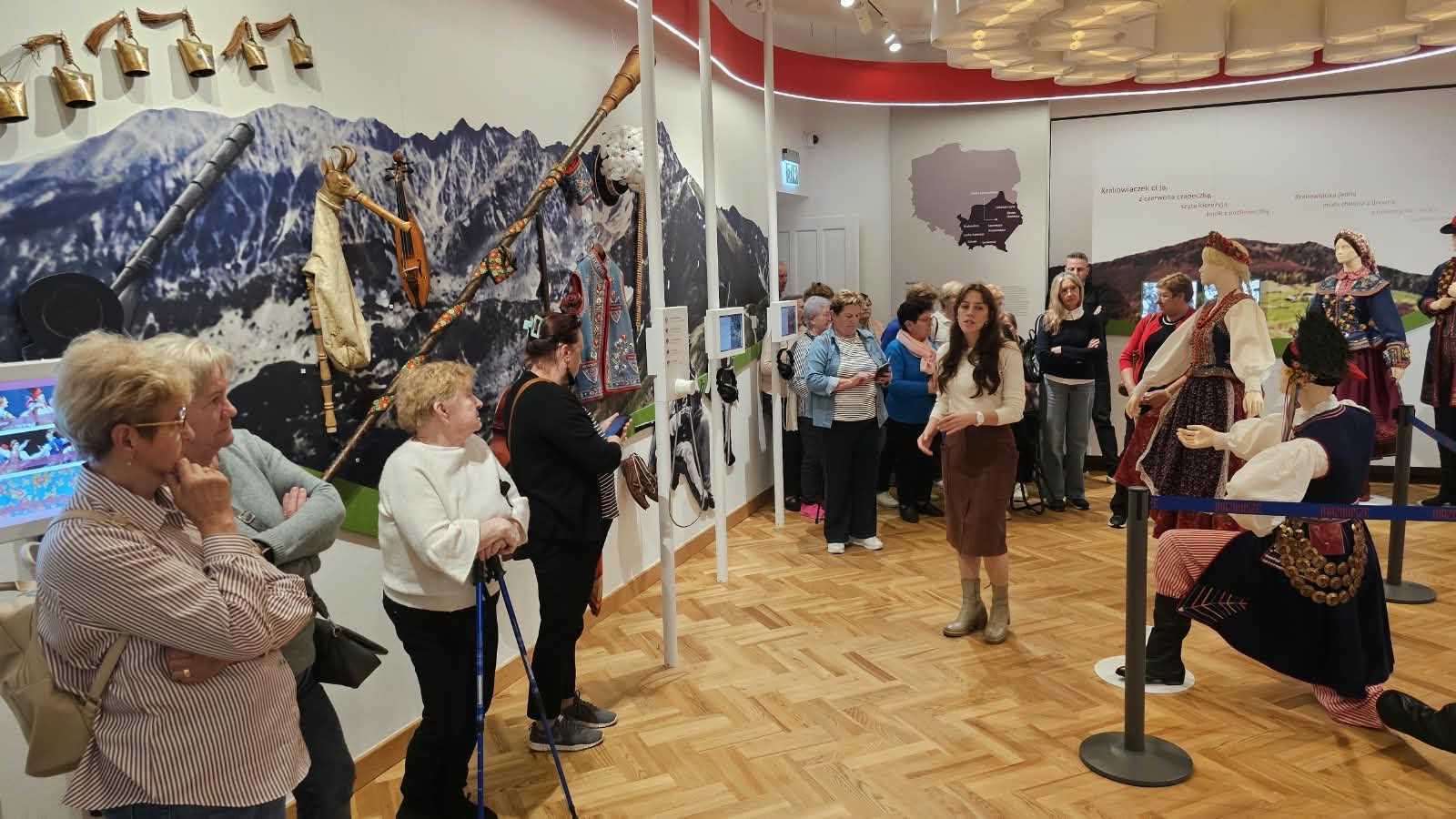 Na zdjęciu widać grupę senior&oacute;w prawdopodobnie w&nbsp;muzeum. W pomiesczeniu widać r&oacute;wnież manekiny ubrane w&nbsp;stroje tradycyjne stroje, najprawdopodobniej mazowszan. Na sianach widać onamalowane g&oacute;ry oraz&nbsp;mapę polski z&nbsp;wyr&oacute;żnionym obszarem małopolski
